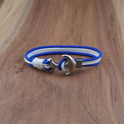Bracelet with blue and white straps and a silver clasp on a wooden surface