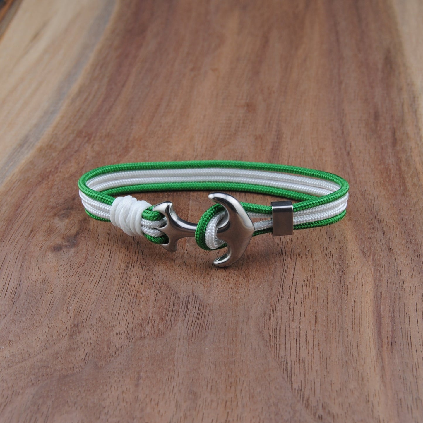 Bracelet with green and white strap on a wooden surface