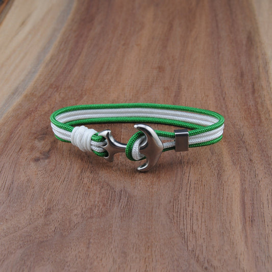 Bracelet with green and white strap on a wooden surface