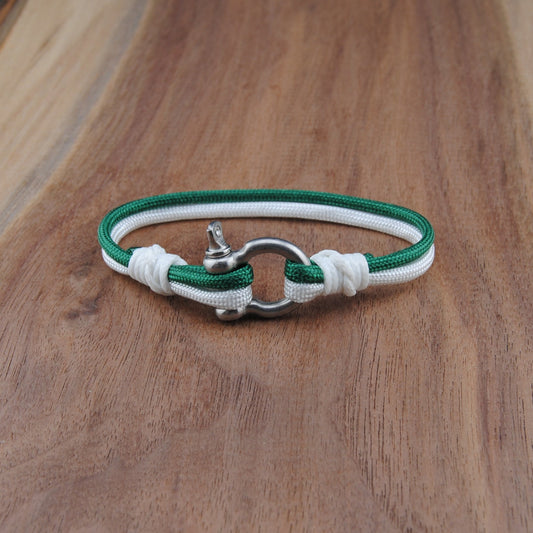 Green and white bracelet with a silver clasp on a wooden surface