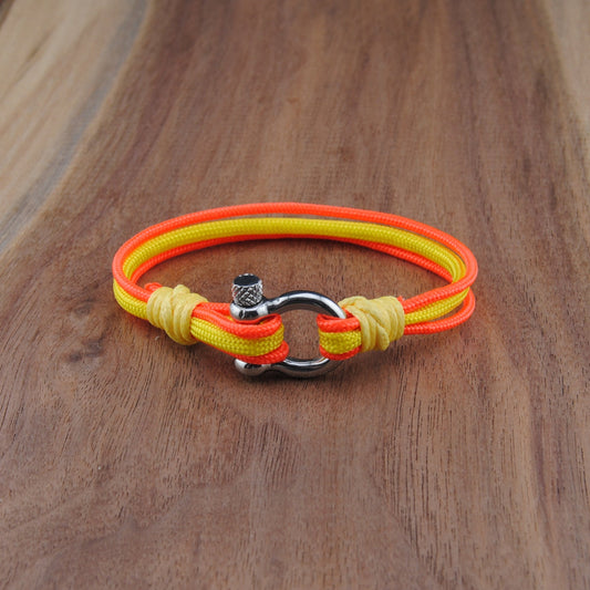 Neon orange and yellow bracelet with a metal clasp on a wooden surface