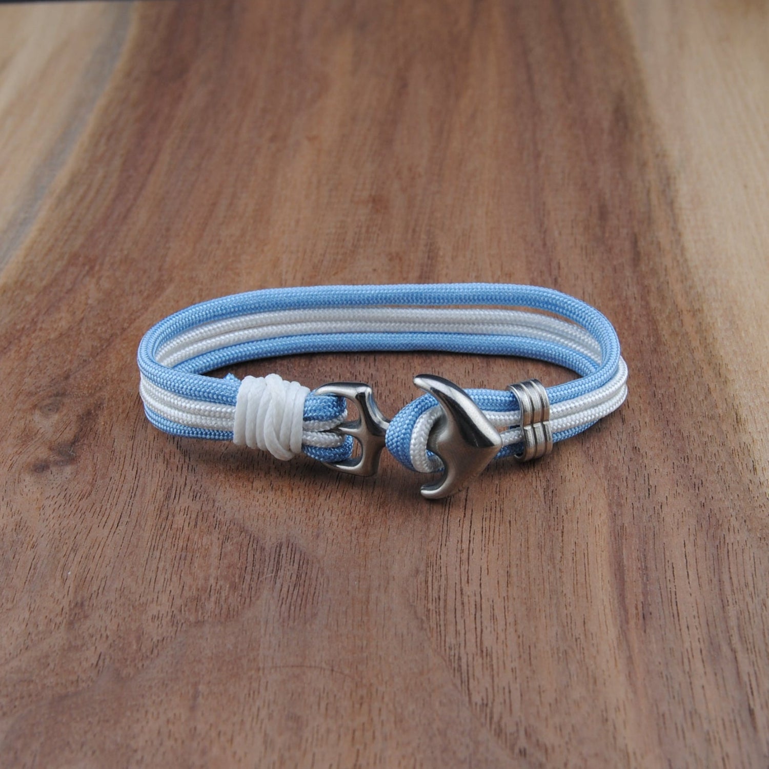 Bracelet with blue and white straps on a wooden surface