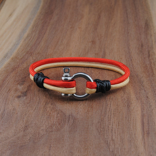 Bracelet with red, and Gold cord on a wooden surface