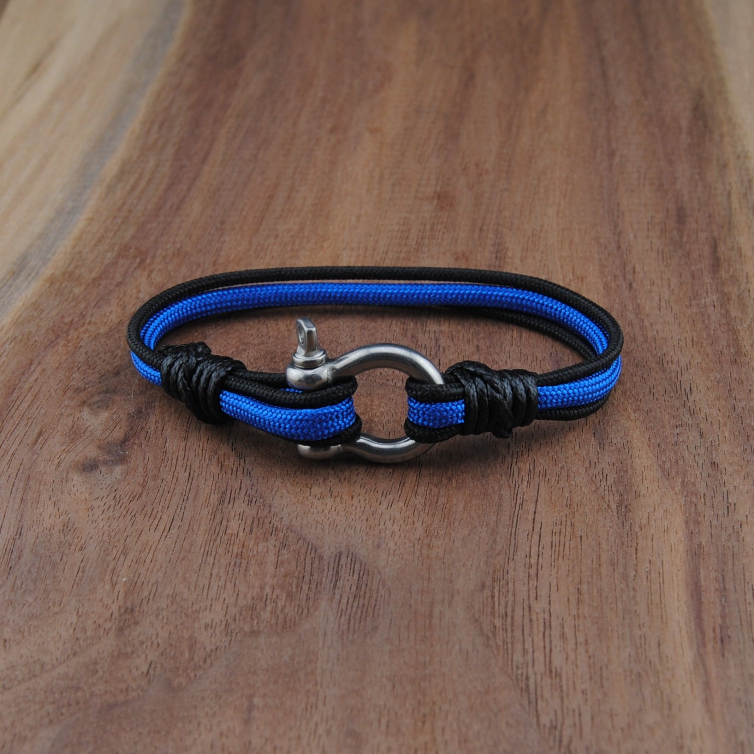 Blue and black braided bracelet on a wooden surface