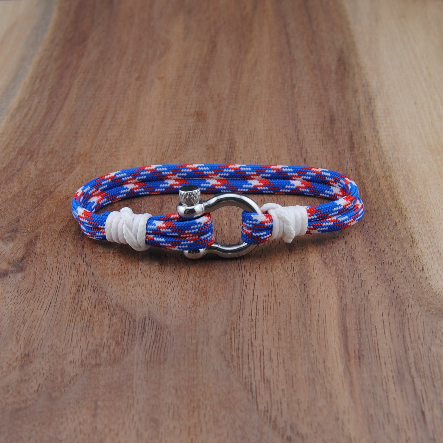 Multicolored braided bracelet with a metal clasp on a wooden surface