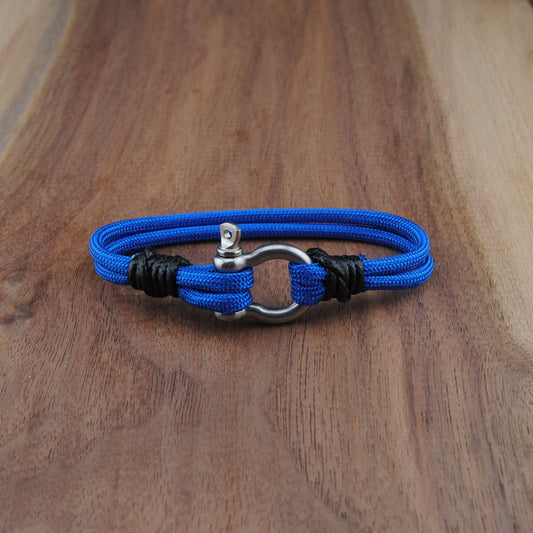 Blue braided bracelet with a silver clasp on a wooden surface
